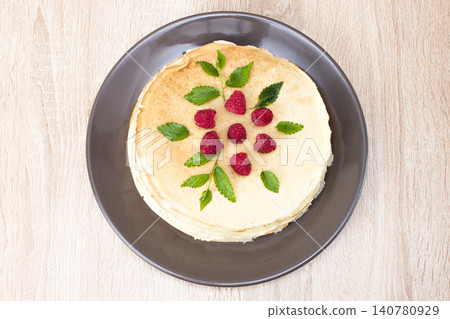 Pancakes with raspberries. Pancakes with raspberries on a brown plate. Pancakes with raspberries on a plate and a wooden board. Pancakes with raspberries. Pancakes with raspberries on a brown plate. Pancakes with raspberries on a plate and a wooden board. 140780929