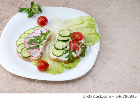 Set of vegetarian sandwiches with vegetables on a plate. Sandwich with cottage cheese, cucumbers and cherry tomatoes and radish on a white plate on the table. Set of vegetarian sandwiches with vegetables on a plate. Sandwich with cottage cheese, cucumbers and cherry tomatoes and radish on a white plate on the table. 140780936