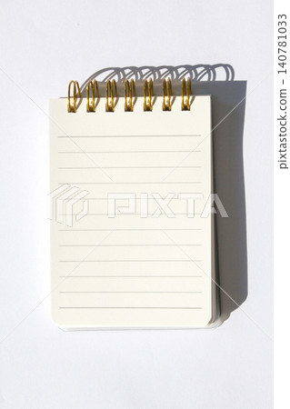 It is a small notebook placed on a white background. It is a small notebook placed on a white background. 140781033