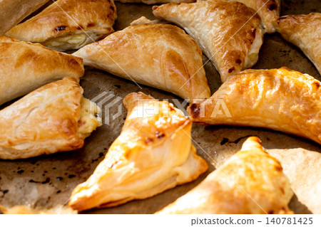 Puff pastry with cottage cheese. Puff pastry triangles with feta cheese on a protvin on a table Puff pastry with cottage cheese. Puff pastry triangles with feta cheese on a protvin on a table 140781425