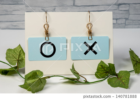 Circles and crosses hanging from a memo clip Circles and crosses hanging from a memo clip 140781888