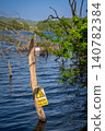 Mercers Lake near Merstham, Surrey, UK with trees on a summer's day. A danger sign warns of deep water. 140782384