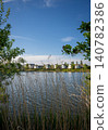A modern housing development next to the Holmethorpe Lagoons in Mersham, Surrey, UK. Trees and reeds in the foreground. Portrait orientation. 140782386