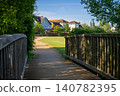 A modern housing development in Mersham, Surrey, UK. A path over a small wooden bridge leads to the houses. 140782395