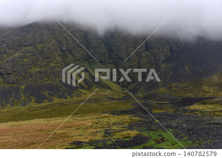 Dramatic volcanic gorge and mountain cliffs hidden in low fog, Iceland Dramatic volcanic gorge and mountain cliffs hidden in low fog, Iceland 140782579