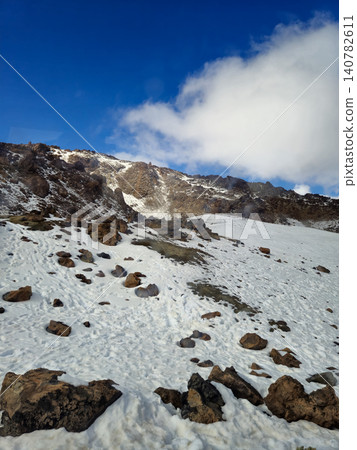 Snowy volcanic mountain slope under blue sky Snowy volcanic mountain slope under blue sky 140782611