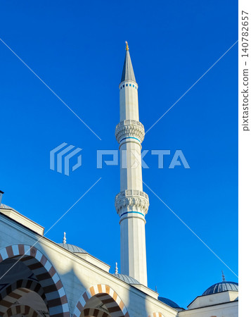 Tall mosque minaret against clear blue sky Tall mosque minaret against clear blue sky 140782657