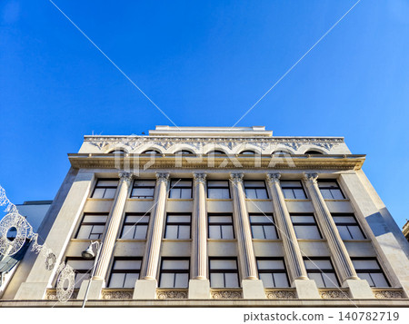 Historic neoclassical building facade against blue sky 140782719