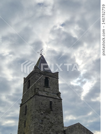 Historic stone tower under dramatic cloudy sky Historic stone tower under dramatic cloudy sky 140782759