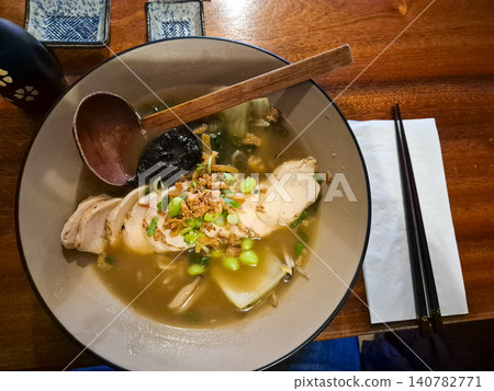 Chicken ramen bowl with chopsticks on wooden table Chicken ramen bowl with chopsticks on wooden table 140782771