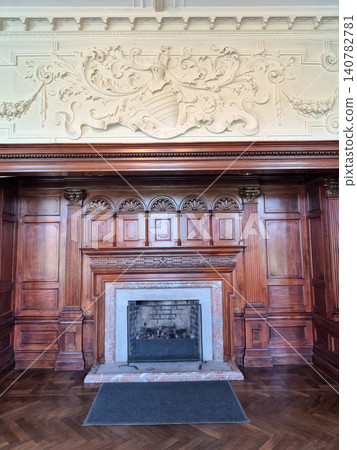 Elegant historic fireplace with carved wood paneling Elegant historic fireplace with carved wood paneling 140782781