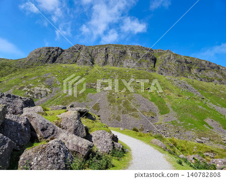 Mountain trail with rocky hillside and blue sky Mountain trail with rocky hillside and blue sky 140782808