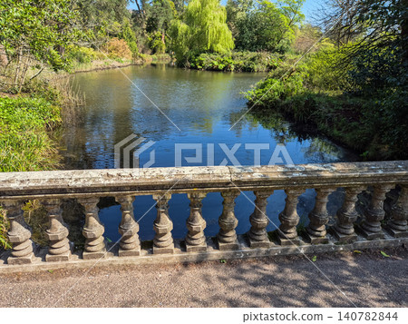 Peaceful park pond with stone balustrade 140782844