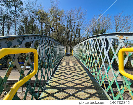 Rusty pedestrian bridge with geometric railings 140782845