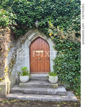 Arched wooden door covered in ivy Arched wooden door covered in ivy 140782861