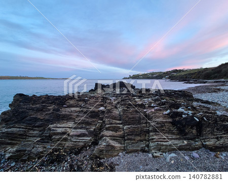 Rocky coastline at dusk with pastel sky 140782881