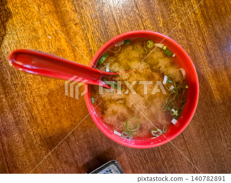 Miso soup in red bowl on wooden table 140782891