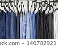 Denim jeans hanging on clothing rack in retail store display 140782921