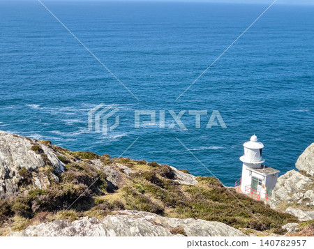 Coastal lighthouse on rocky cliff overlooking sea Coastal lighthouse on rocky cliff overlooking sea 140782957