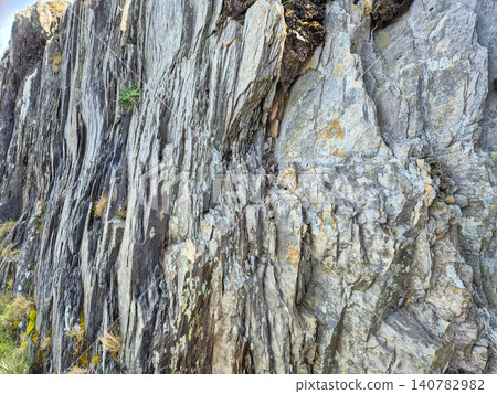Rugged cliff face with layered rock texture Rugged cliff face with layered rock texture 140782982