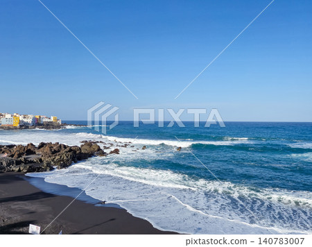 Rocky coastline with waves and seaside town 140783007