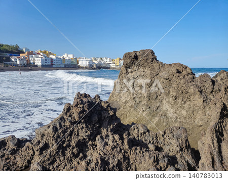 Rocky seaside coastline with village beach and waves Rocky seaside coastline with village beach and waves 140783013