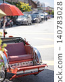 Colorful trishaw with red umbrella parked on a sunny street 140783028