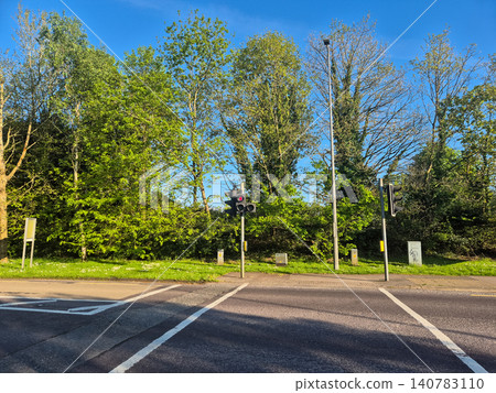 Quiet roadside intersection with traffic lights and trees Quiet roadside intersection with traffic lights and trees 140783110