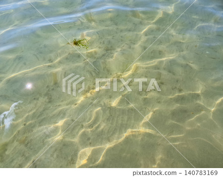 Clear shallow sea water with sunlit ripples Clear shallow sea water with sunlit ripples 140783169
