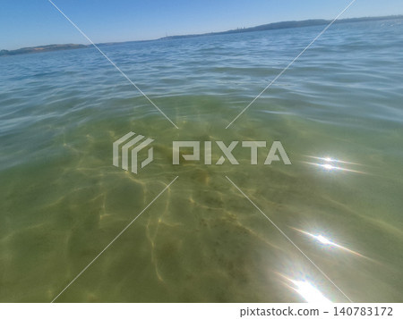 Sunlit Clear Ocean Water with Gentle Ripples 140783172
