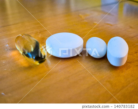Assorted pills on wooden table 140783182