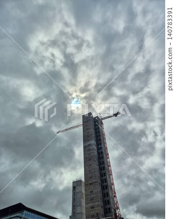 High-rise building construction under dramatic cloudy sky High-rise building construction under dramatic cloudy sky 140783391