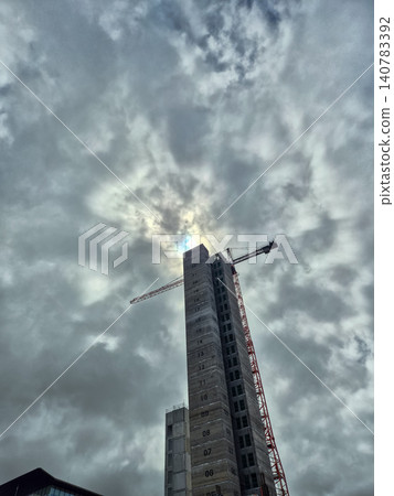 High Rise Tower Crane Under Dramatic Cloudy Sky High Rise Tower Crane Under Dramatic Cloudy Sky 140783392