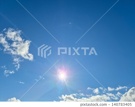 Bright blue sky with sun and scattered clouds Bright blue sky with sun and scattered clouds 140783405