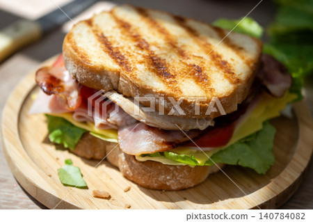 Grilled Club Sandwich with Chicken, Bacon, Cheese and Fresh Vegetables Grilled Club Sandwich with Chicken, Bacon, Cheese and Fresh Vegetables 140784082