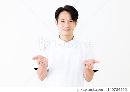 A middle-aged male acupuncturist/osteopath wearing a white coat. A middle-aged male acupuncturist/osteopath wearing a white coat. 140784233