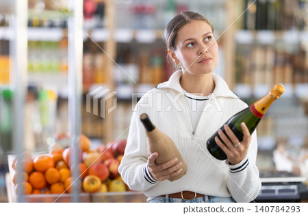 customer chooses champagne and wine in the store customer chooses champagne and wine in the store 140784293