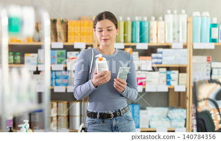Young girl choosing cream in drugstore Young girl choosing cream in drugstore 140784356