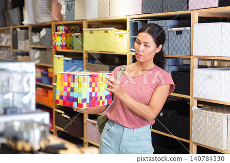 Asian female standing with basket in shop Asian female standing with basket in shop 140784530