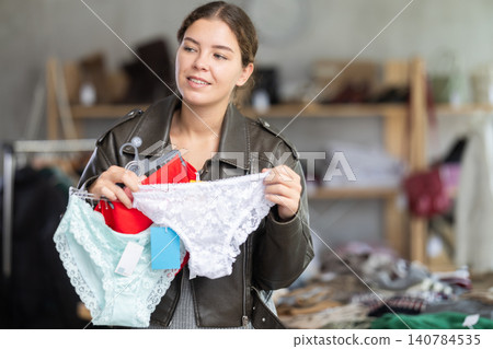 Glad young girl choosing panties in clothing store 140784535