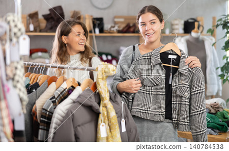 Two young women choosing outerwear in store Two young women choosing outerwear in store 140784538