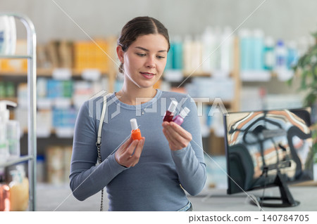 Young woman choosing nail polish in drugstore 140784705