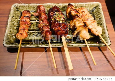 一盤各式烤雞肉串,擺放在日式盤上。 一盤各式烤雞肉串,擺放在日式盤上。 140784777