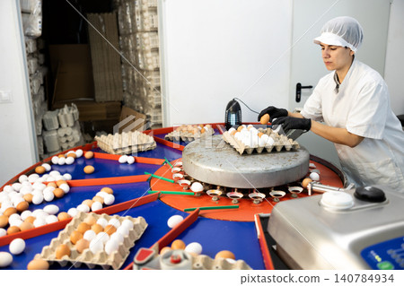 Focused young Latin female farmer worker in uniform sorting and labeling chicken eggs on farm Focused young Latin female farmer worker in uniform sorting and labeling chicken eggs on farm 140784934