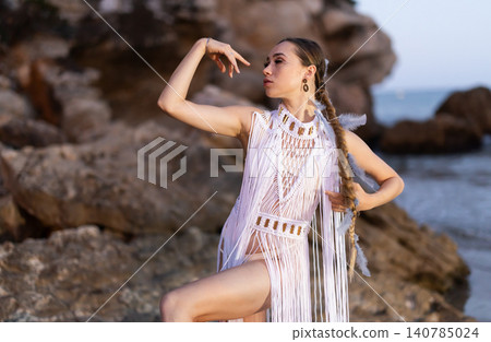 Girl on seashore in sexy and revealing Amazon tribe carnival costume and boots Girl on seashore in sexy and revealing Amazon tribe carnival costume and boots 140785024