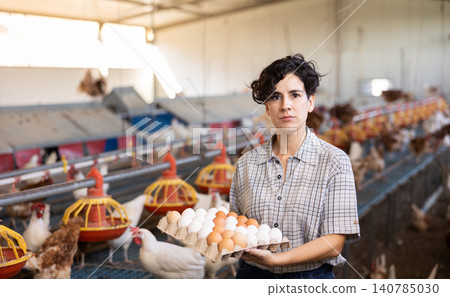 Young Latin female farmer worker holding cardboard box full of fresh chicken eggs on poultry farm Young Latin female farmer worker holding cardboard box full of fresh chicken eggs on poultry farm 140785030