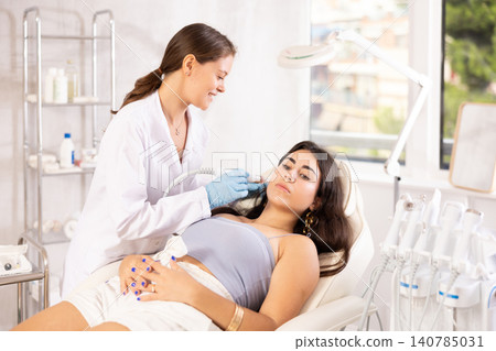 Aesthetician administering facial procedure on woman using ion bubble attachment Aesthetician administering facial procedure on woman using ion bubble attachment 140785031