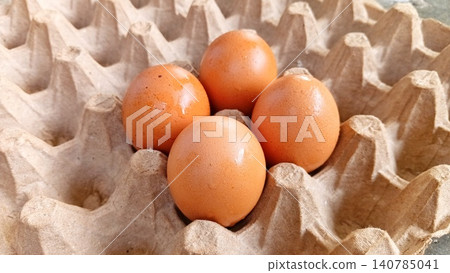 Close-up of four fresh uncooked eggs in a tray or egg carton. Close-up of four fresh uncooked eggs in a tray or egg carton. 140785041