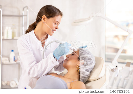 European doctor making Beauty procedure to brunette girl (skin cleaning) European doctor making Beauty procedure to brunette girl (skin cleaning) 140785101