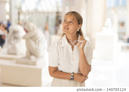 Woman with sheet piece of paper in hands view sculpture in museum hall Woman with sheet piece of paper in hands view sculpture in museum hall 140785124